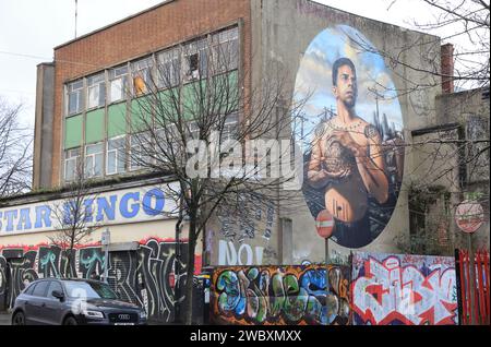 Mikey - L'homme au tatouage atomique, peint par Voyder en 2023, sur North Street/McKibben's court. Mikey est photographié dans un chantier de fret, à Belfast, au Royaume-Uni Banque D'Images