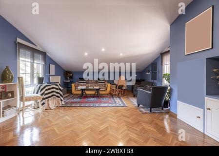 Salle de séjour mansardée d'une maison d'habitation unifamiliale avec parquet en chêne français posé dans un motif à chevrons Banque D'Images