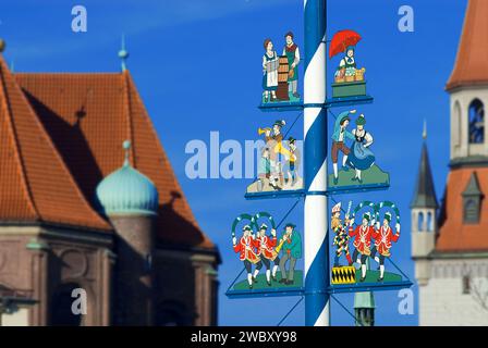 Maypole sur Viktualienmarkt avec musiciens, couple dansant, femme du marché, serveuse de l'Oktoberfest, tour de la nouvelle mairie en arrière-plan, Munich, Bavari Banque D'Images