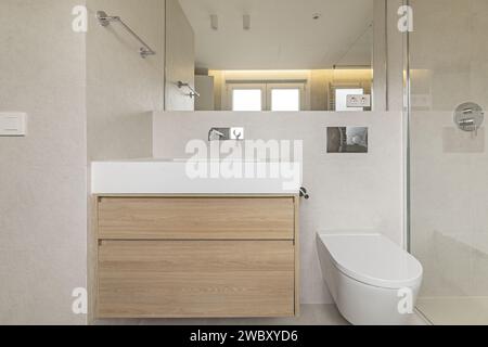 Façade de salle de bain avec mobilier flottant au design moderne en bois de chêne blanc, miroir intégré au mur, robinets en acier chromé, verre trempé Banque D'Images