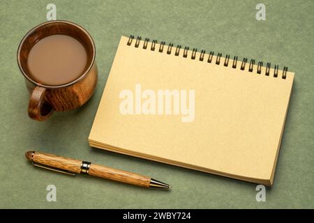 carnet à croquis en spirale vierge sur papier texturé avec une tasse de café, plat de bureau Banque D'Images