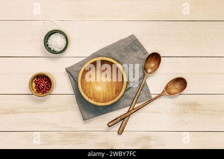 Nature morte avec quelques cuillères en bois avec un bol en bois de bambou et quelques épices et flocons de sel dans de petits récipients Banque D'Images