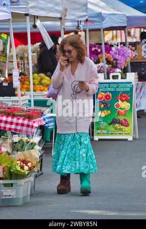 Carmel, Californie, États-Unis - 14 décembre 2023 une femme vérifie sa liste de courses au marché hebdomadaire des fermiers/de rue de CarmelÕs sur la 6e rue par Devendorf Park Banque D'Images