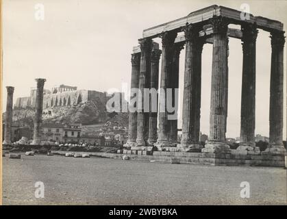 Acropole et Temple à Athènes, c. 1930 - c. 1940 photo Magazine Album avec une photo du temple du Zeus olympique avec l'Acropole à Athènes en arrière-plan, l'une des escales du vol KLM Amsterdam-Batavia. Partie de l'album commémoratif de la ligne Indes de KLM, partie I. Papier Athene. support photographique. carton gélatine argent impression trafic aérien, aviation. voyages ; tourisme. paysage avec ruines. Colonne, pilier  architecture Athene. Akropolis Banque D'Images