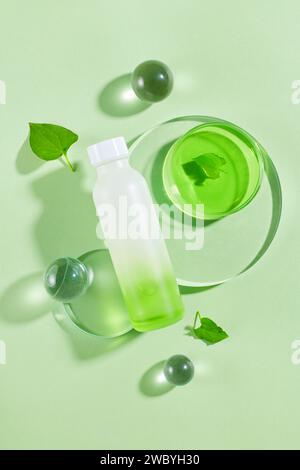 Podium transparent en forme de rond avec bouteille non étiquetée et une boîte de Pétri remplie de liquide placé sur. La menthe de poisson (Houttuynia cordata) a de nombreux avantages Banque D'Images