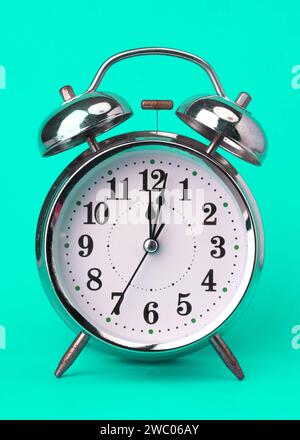 Réveil vintage classique isolé sur fond vert. Réveil rétro avec douze heures. Banque D'Images