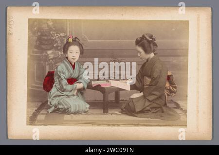 Double portrait de deux japonaises inconnues en lisant, Anonymous, 1860 - 1900 photographie Japan paper. lecture d'imprimés d'albumen en carton. Personnages historiques anonymes représentés dans un double portrait du Japon Banque D'Images