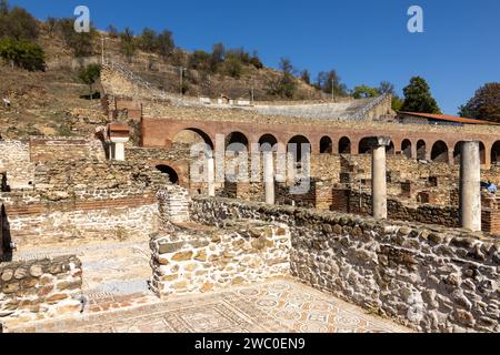 Anciennes colonnes de pierre, une belle mosaïque et le vieil amphithéâtre en arrière-plan dans la ville historique de Heraclea Lyncestis près de Bitola moderne. Banque D'Images