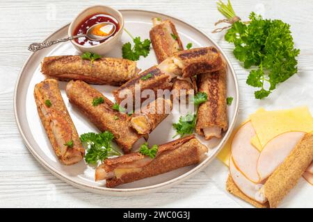 pain grillé français au jambon et au fromage au blé entier servi avec une sauce chili sucrée sur une assiette sur une table en bois blanc, vue horizontale Banque D'Images