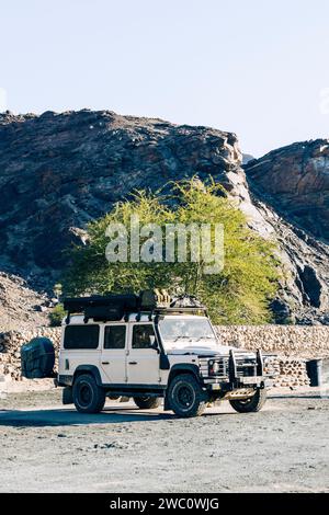 Un vieux Land Rover britannique blanc avec du matériel de camping est stationné dans un camping à AIS AIS, Namibie Banque D'Images