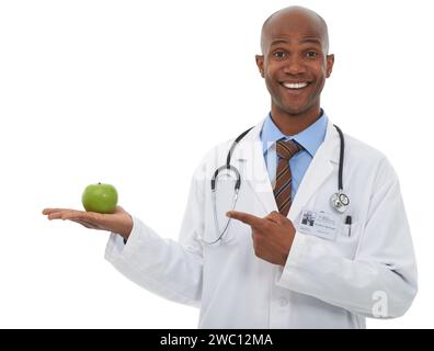Portrait, homme noir et médecin point à la présentation de pomme pour la perte de poids régime, nutrition ou avantages antioxydants. Cuisine studio, palmier et africain Banque D'Images