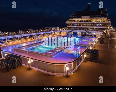 Vue nocturne de la terrasse principale de la piscine (The Atmosphere Pool) sur le MSC Euribia naviguant en Europe du Nord (23 juillet). Banque D'Images