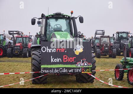 Hohenlockstedt, Allemagne. 13 janvier 2024. Plusieurs milliers de participants manifestent à l'aérodrome de Hungry Wolf contre la politique du gouvernement allemand. Les agriculteurs ont demandé que la suppression progressive de la subvention au diesel agricole soit annulée. L'industrie de la construction a exigé un catalogue de mesures en 14 points pour soutenir le secteur. Crédit : Georg Wendt/dpa/Alamy Live News Banque D'Images