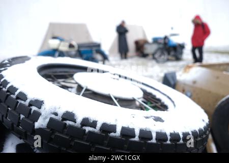 Augustusburg, Allemagne. 13 janvier 2024. Une roue de secours enneigée à la rencontre hivernale des motocyclistes au château d'Augustusburg. La traditionnelle réunion des motards a lieu pour la 51e fois. Crédit : Sebastian Willnow/dpa/Alamy Live News Banque D'Images