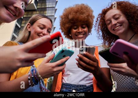 Joyeux groupe de jeunes amies multiraciales utilisant des smartphones accro à la technologie Banque D'Images