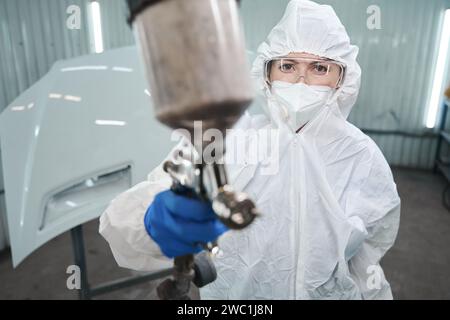 Maître de peinture avec un réservoir d'injection de peinture dans ses mains Banque D'Images