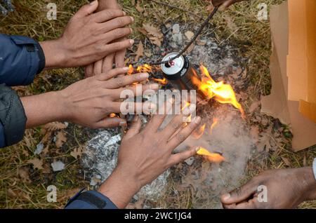 Les réfugiés se réchauffent les mains au-dessus du feu lors de la froide journée d'hiver. Des milliers de migrants en Bosnie-Herzégovine piégés sur la route des Balkans. Banque D'Images