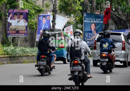 Bogor, Java Ouest, Indonésie. 13 janvier 2024. Les motocyclistes ont passé devant le panneau d'affichage d'une paire de candidats et d'autres candidats législatifs le long d'une rue à Bogor, Java Ouest, Indonésie le 13 janvier 2024, avant les prochaines élections générales en Indonésie prévues pour le 14 février. (Image de crédit : © Adriana Adie/ZUMA Press Wire) USAGE ÉDITORIAL SEULEMENT! Non destiné à UN USAGE commercial ! Banque D'Images