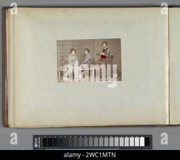 Portrait de trois japonaises avec du thé, Anonyme, c. 1870 - c. 1891 photographie partie de l'album photo d'un voyage à Manille. Papier japonais. support photographique imprimé albumine femme adulte. thé et café-service Japon Banque D'Images