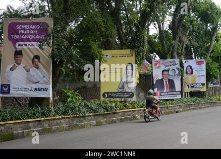 Bogor, Java Ouest, Indonésie. 13 janvier 2024. Un homme monte à vélo devant le panneau d'affichage des candidats à la législature le long d'une rue à Bogor, Java Ouest, Indonésie le 13 janvier 2024, avant les prochaines élections générales en Indonésie prévues pour le 14 février. (Image de crédit : © Adriana Adie/ZUMA Press Wire) USAGE ÉDITORIAL SEULEMENT! Non destiné à UN USAGE commercial ! Banque D'Images