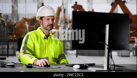 Ingénieur utilisant le PC dans la chaîne d'assemblage automatisée d'usine de voiture Banque D'Images