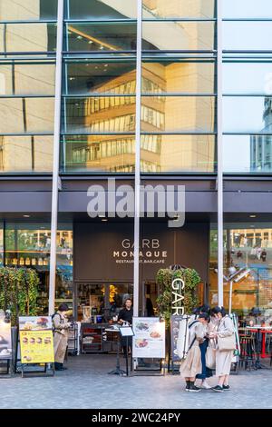 Gros plan, entrée au Garb Monaque Italian Restaurant Bar dans la salle des navires Umekita. Portier avec masque facial devant la porte, panneaux de menu sur la plaza. Banque D'Images