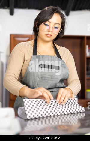 belle jeune femme travaillant dans la cuisine, préparant des emballages de restauration rapide avec du papier, mode de vie dans le restaurant, travail de la personne Banque D'Images