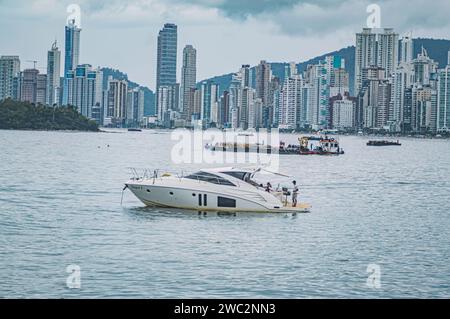 Balneario Camboriú-sc, Brésil-janvier 11,2024, bâtiments dans le centre-ville dans une rue de Balneário Camboriú par temps nuageux, un yacht dans l'image. Banque D'Images