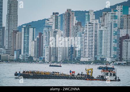 Balneario Camboriú-sc, Brésil-janvier 11,2024, bâtiments dans le centre-ville dans une rue de Balneário Camboriú par temps nuageux, un yacht dans l'image. Banque D'Images