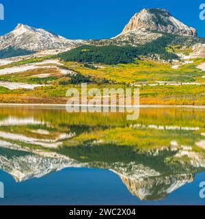 couleurs d'automne au-dessous de coeur butte et plume femme montagne reflétée dans le lac vert près de coeur butte, montana Banque D'Images