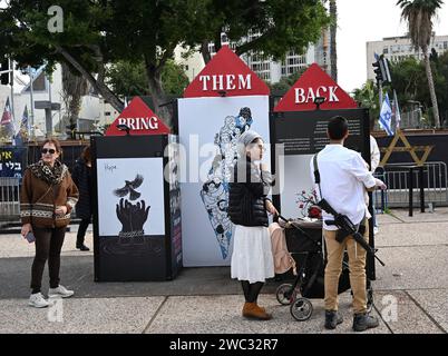 Tel Aviv, Israël. 13 janvier 2024. Les gens regardent des expositions pour les Israéliens toujours retenus en otage à Gaza par le Hamas sur la place des otages à tel Aviv le samedi 13 janvier 2024. Le 14 janvier, Israël marquera cent jours depuis le massacre du Hamas sur Israël et appellera à la libération des 136 otages encore détenus par le Hamas à Gaza. Photo de Debbie Hill/ crédit : UPI/Alamy Live News Banque D'Images