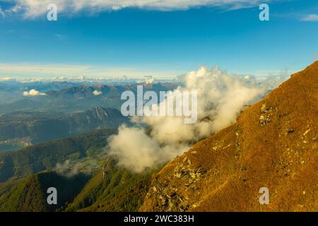 Vue aérienne sur le magnifique paysage montagneux avec des nuages et le lac de Lugano et la ville de Lugano dans une journée ensoleillée au Tessin, en Suisse Banque D'Images