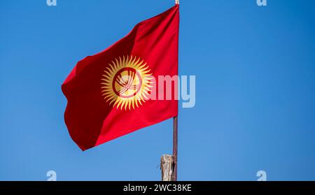 Drapeau national kirghize devant un ciel bleu, Kirghizistan Banque D'Images