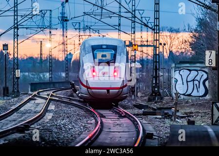 Ligne de chemin de fer avec de nombreuses lignes aériennes et signaux ferroviaires, InterCityExpress ICE de Deutsche Bahn AG, feux arrière dans la lumière du soir, Stuttgart Banque D'Images