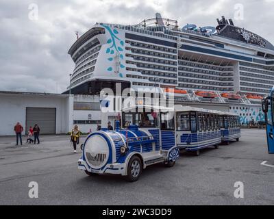 Train touristique en attente pour les clients sous le bateau de croisière MSC Euribia amarré à Ålesund, Norvège. Banque D'Images