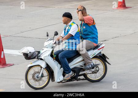 SAMUT PRAKAN, THAÏLANDE, NOVEMBRE 03 2023, deux chauffeurs de taxi moto roulent ensemble sur une seule moto Banque D'Images