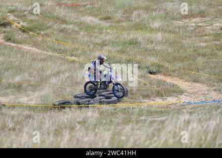 Dans la course de moto extrême Enduro, les coureurs ont concouru sur des terrains difficiles en sautant par-dessus des pneus sur un sol et une balade de 40 kilomètres sur des sentiers de montagne. Banque D'Images