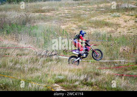 Dans la course de moto extrême Enduro, les coureurs ont concouru sur des terrains difficiles en sautant par-dessus des pneus sur un sol et une balade de 40 kilomètres sur des sentiers de montagne. Banque D'Images