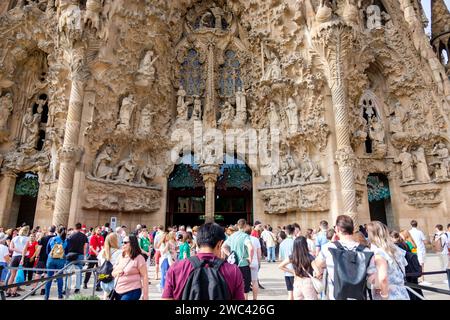 Surtourisme, foule touristique qui attend à l'extérieur devant la façade de la Nativité pour visiter la basilique la Sagrada Familia, par Antoni Gaudí, Barcelone, Espagne Banque D'Images