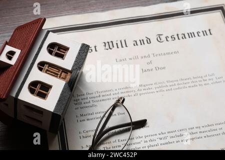 Last Will et Testament, modèle de maison et verres sur table en bois, gros plan Banque D'Images