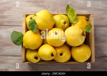 Savoureux fruits de coing mûrs dans la caisse sur la table en bois, vue de dessus Banque D'Images