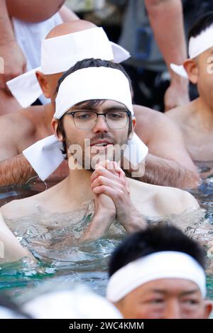 Tokyo, Japon. 14 janvier 2024. Un participant étranger prie dans une piscine d'eau glacée pendant la cérémonie annuelle de purification des bains d'eau glacée (Kanchu-Suiyoku) au sanctuaire Teppozu Inari. Environ 87 participants courageux se sont joints au rituel de purification pour prier pour une nouvelle année saine. (Image de crédit : © Rodrigo Reyes Marin/ZUMA Press Wire) USAGE ÉDITORIAL SEULEMENT! Non destiné à UN USAGE commercial ! Banque D'Images