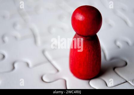 Une poupée en bois rouge unique sur puzzle. Banque D'Images