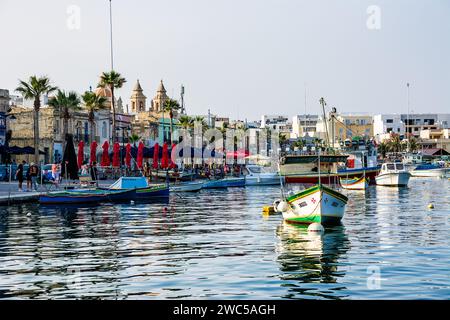 Marsaxlokk, Malte - 18 juin 2023 : bord de mer et port avec des bateaux amarrés Banque D'Images