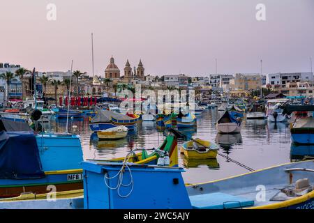 Marsaxlokk, Malte - 18 juin 2023 : bord de mer et port avec des bateaux amarrés Banque D'Images