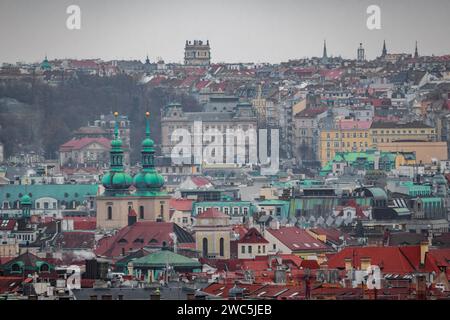 Une vue sur le paysage urbain de la vieille ville médiévale historique de Prague avec de nombreux toits. Il y a une église et une tour. Il faisait froid glacial en hiver Banque D'Images