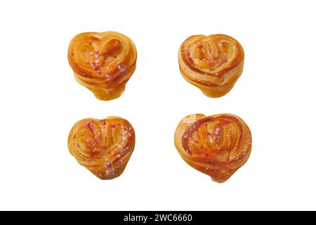 Petits pains en forme de coeur isolés sur blanc. Pâtisserie maison saupoudrée de sucre en poudre. Petits pains sucrés dorés frais cuits au four. Banque D'Images