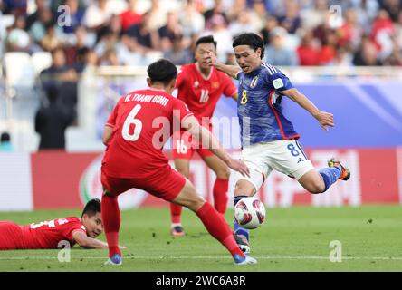 Doha, Qatar. 14 janvier 2024. Minamino Takumi (R) du Japon tire lors du match du Groupe D entre le Japon et le Vietnam à la coupe d’Asie de l’AFC à Doha, Qatar, le 14 janvier 2024. Crédit : CAO CAN/Xinhua/Alamy Live News Banque D'Images