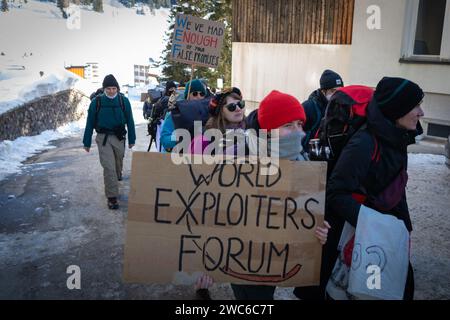 Davos, Suisse. 14 janvier 2024. Davos, CH 14 janvier 2024. Les manifestants portent une banderole qui se rend à Davos pour protester contre le 54e Forum économique mondial. Des centaines de manifestants se sont rassemblés pour exprimer leurs préoccupations au sujet de l'ordre du jour du FEM de cette année. Le Forum engage les dirigeants politiques, commerciaux et culturels de la société à façonner les agendas mondiaux, régionaux et industriels, qui peuvent avoir un impact sur tout le monde dans le monde. Crédit : Andy Barton/Alamy Live News Banque D'Images