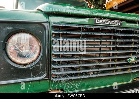 Toiles d'araignée dewy sur la grille avant d'un vieux Land Rover Defender, Hampshire, Royaume-Uni Banque D'Images